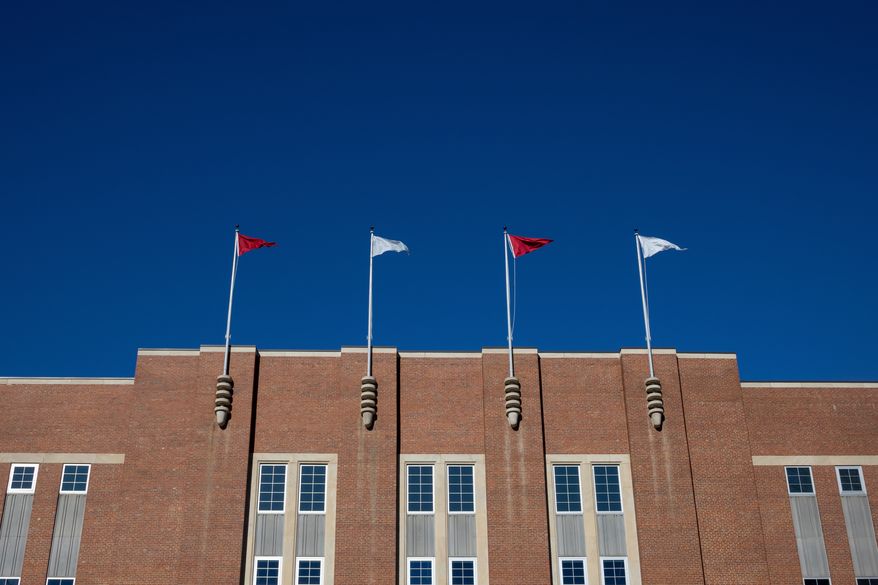 Flags fly above at the Reynolds Coliseum on the campus of North Carolina State University, Feb. 19, 2022, in Raleigh, N.C. (AP Photo/Kara Durrette, File)