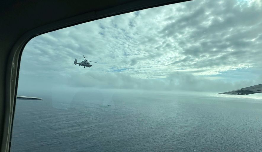 A Chinese military helicopter flies close to a Philippine Bureau of Fisheries and Aquatic (BFAR) aircraft above Scarborough shoal on Feb. 18, 2025. (AP Photo/Joeal Calupitan, File)