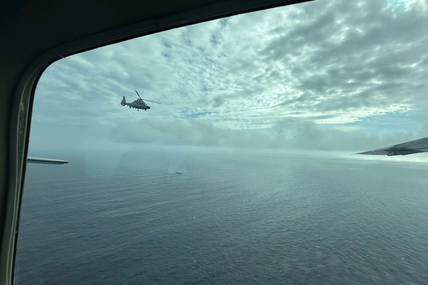 A Chinese military helicopter flies close to a Philippine Bureau of Fisheries and Aquatic (BFAR) aircraft above Scarborough shoal on Feb. 18, 2025. (AP Photo/Joeal Calupitan, File)