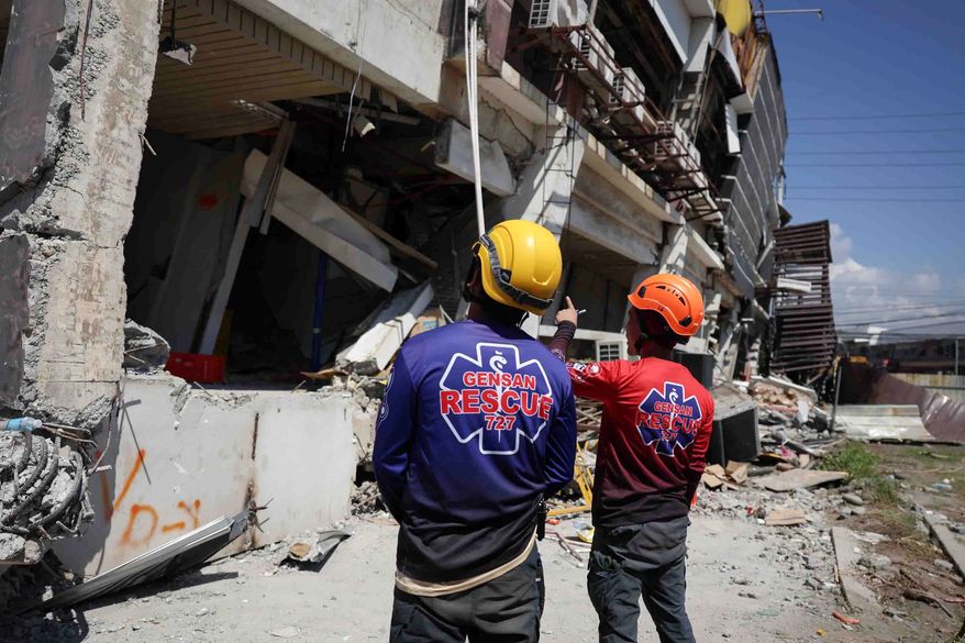 Rescuers inspect a damaged building following an earhtquake in General Santos, Philippines Tuesday, June 9, 2026. (AP Photo/Basilio Sepe)