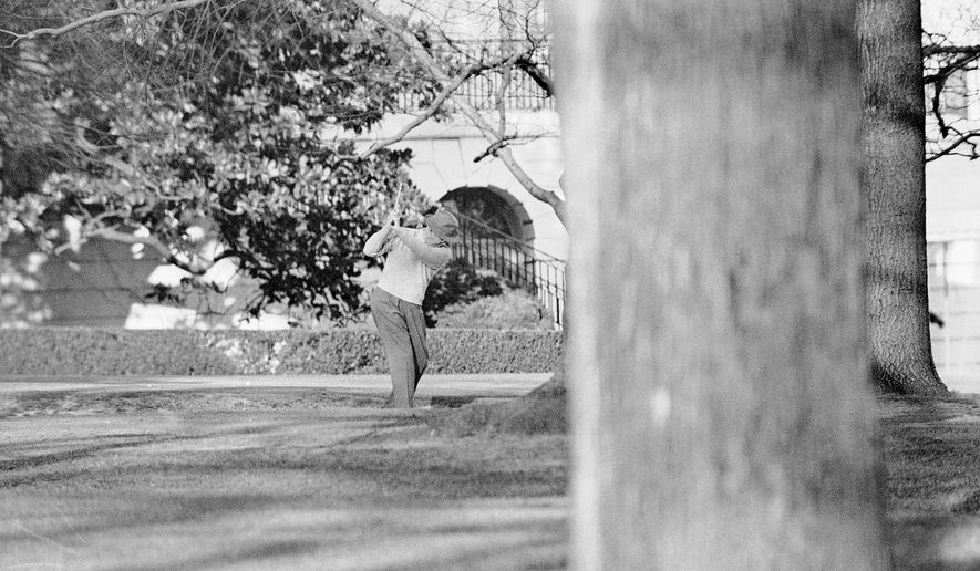 President Dwight Eisenhower brushes up on his golf game near the putting green on the lawn of the White House, Jan. 13, 1959, in Washington. (AP Photo, File)