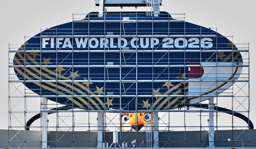 Workers cover a Kansas City Chiefs sign to FIFA World Cup 2026 as work continues to transform Arrowhead Stadium to Kansas City Stadium ahead of the FIFA World Cup soccer tournament Monday, June 8, 2026, in Kansas City, Mo. (AP Photo/Charlie Riedel)