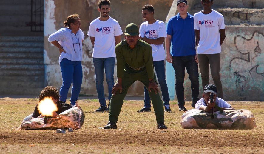 Civilians fire blanks during basic military training given by soldiers who rotate weekly lessons through different neighborhoods, called "Defense Day," in Havana, Cuba, Friday, March 27, 2026. (AP Photo/Ramon Espinosa)