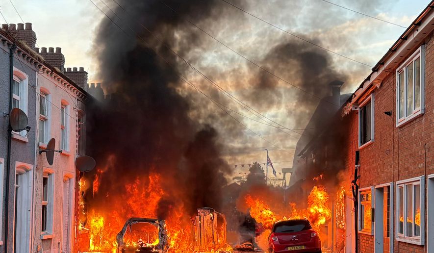 Vehicles set on fire by protesters burn on Lendrick Street in east Belfast, Northern Ireland, on Tuesday, June 9, 2026, after the arrest of a Sudanese man accused of stabbing a man in the northern part of the city. (PA via AP)