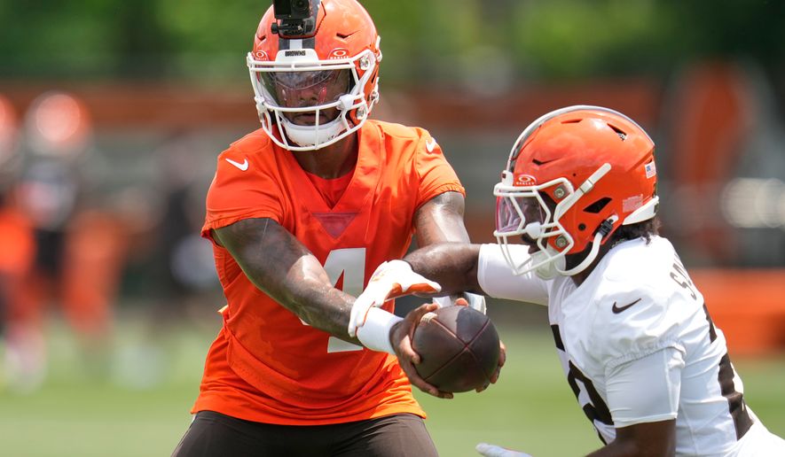 Cleveland Browns quarterback Deshaun Watson, left, hands off to running back Dylan Sampson, right, during the teams' NFL football practice, Wednesday, June 10, 2026, in Berea, Ohio. (AP Photo/Sue Ogrocki)