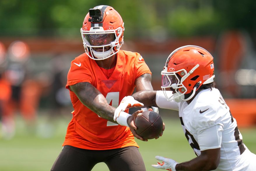 Cleveland Browns quarterback Deshaun Watson, left, hands off to running back Dylan Sampson, right, during the teams' NFL football practice, Wednesday, June 10, 2026, in Berea, Ohio. (AP Photo/Sue Ogrocki)