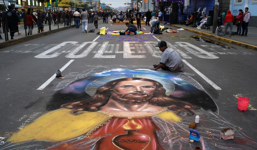 A man works on a chalk drawing depicting the Sacred Heart of Jesus, Oct. 28, 2017, in Lima, Peru. (AP Photo/Martin Mejia, File)