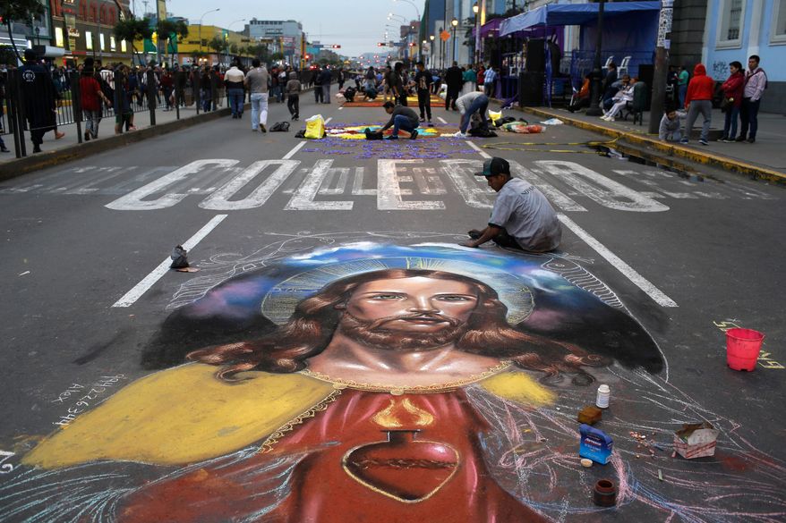 A man works on a chalk drawing depicting the Sacred Heart of Jesus, Oct. 28, 2017, in Lima, Peru. (AP Photo/Martin Mejia, File)
