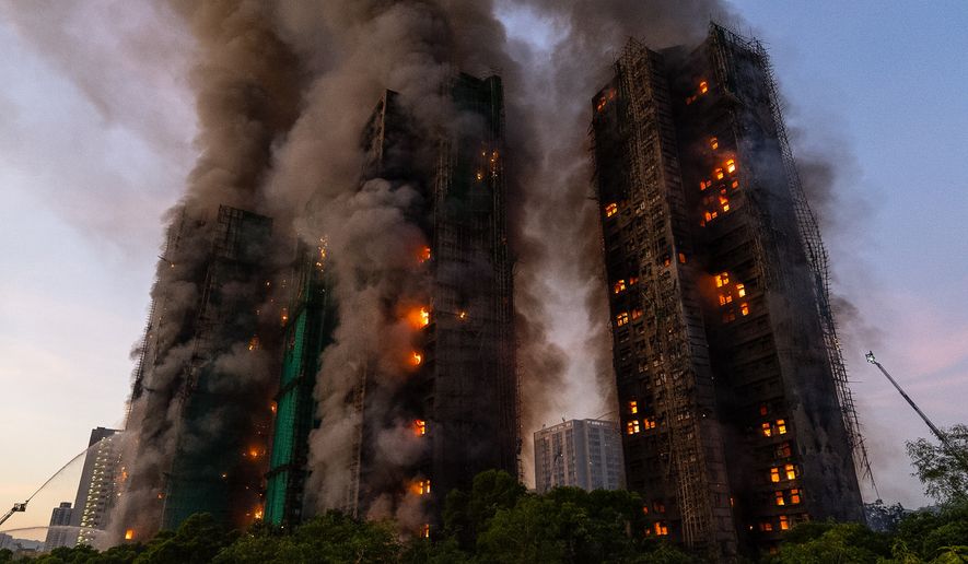 FILE - Smoke rises after a fire broke out at Wang Fuk Court, a residential estate in the Tai Po district of Hong Kong's New Territories, Nov. 26 2025. (AP Photo/Chan Long Hei, File)