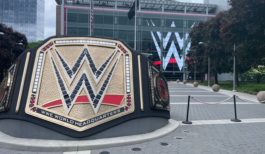 A large replica of the pro wrestling championship belt stands outside in a plaza in front of the world headquarters of WWE in Stamford, Connecticut. File photo credit: James Kirkikis via Shutterstock.