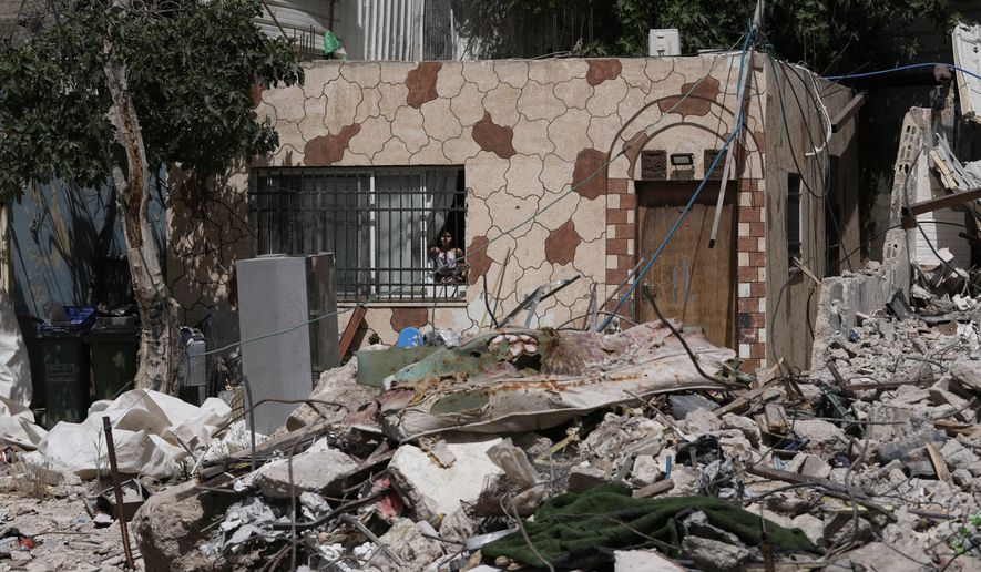 A Palestinian girl looks out a window at the rubble of a home demolished by Israeli authorities in the Silwan neighborhood of east Jerusalem, May 19, 2026. (AP Photo/Mahmoud Illean)