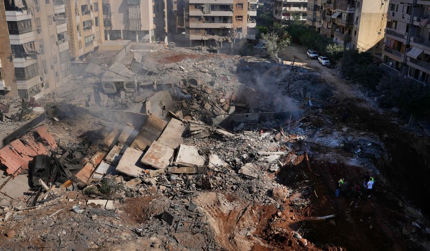 FILE - People gather at the site of the assassination of Hezbollah leader Hassan Nasrallah in Beirut's southern suburbs, Sept. 29, 2024. (AP Photo/Hassan Ammar, File)