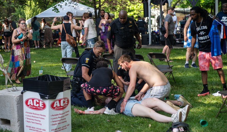 Police treat a person after multiple people were shot at a community festival Saturday, June 6, 2026, in Toledo, Ohio. (Rich Berry via AP)