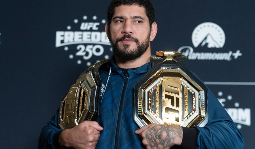 Former UFC light heavyweight champion Alex Pereira from Brazil, holds his championship belts during the UFC Freedom 250 media day, Wednesday, June 10, 2026, in Washington. (AP Photo/Manuel Balce Ceneta)