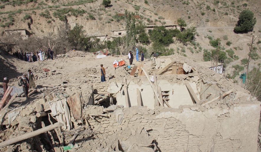 Residents stand on the ruins of mud-brick homes after airstrikes that Taliban officials said were carried out by Pakistan and killed civilians, including children, in Mana, a village in Afghanistan's Khost province, Wednesday, June 10, 2026. (AP Photo/Saifullah Zahir)