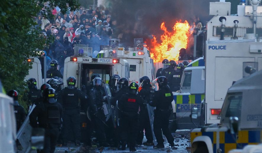 Police attempt to clear protesters near Newtownabbey, in Belfast, Northern Ireland, Wednesday, June 10, 2026, following a stabbing incident on Monday night. (AP Photo/Peter Morrison)