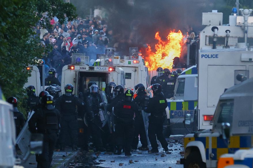 Police attempt to clear protesters near Newtownabbey, in Belfast, Northern Ireland, Wednesday, June 10, 2026, following a stabbing incident on Monday night. (AP Photo/Peter Morrison)