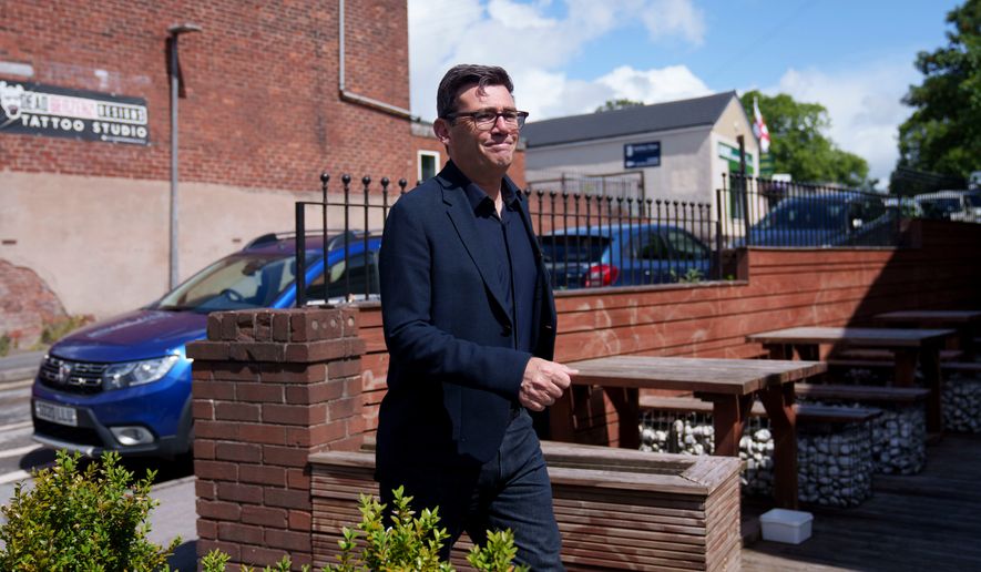 Andy Burnham walks during a campaign visit to the town of Ashton-in-Makerfield before the forthcoming Makerfield by-election, in Greater Manchester, England, Tuesday, June 9, 2026. (AP Photo/Jon Super)