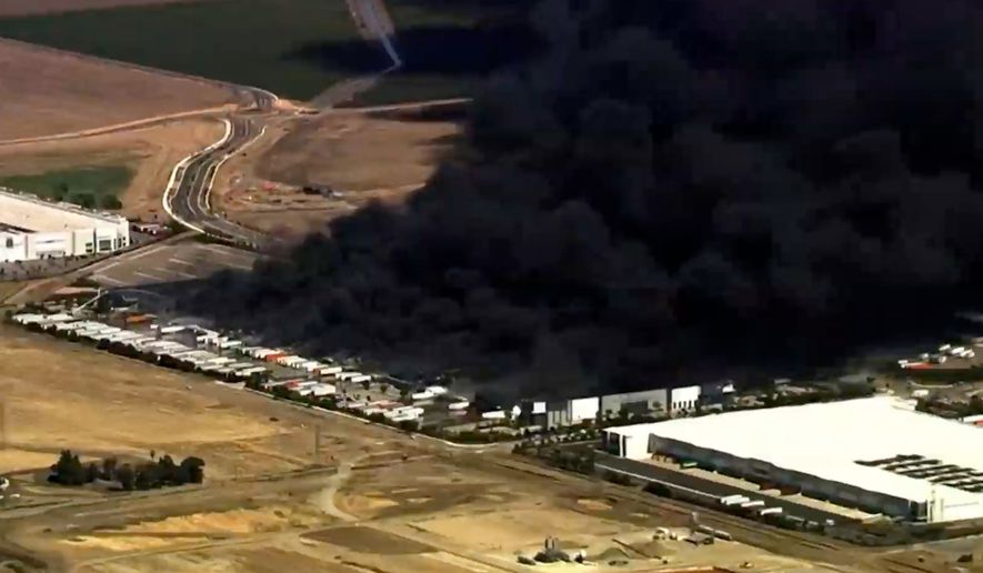 This image from aerial video shows black smoke pouring into the sky from a fire at a medical equipment warehouse in Tracy, Calif., Thursday, June 11, 2026. (KGO via AP)
