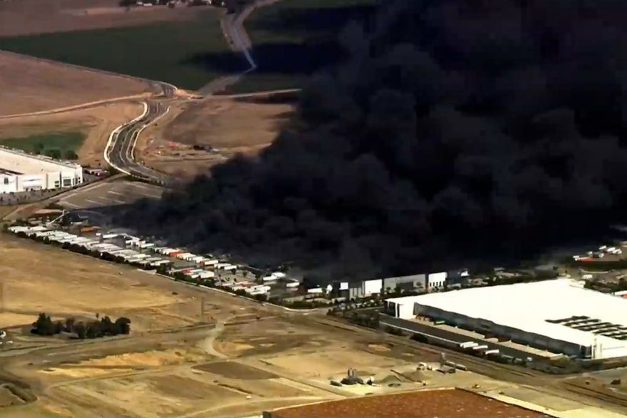 This image from aerial video shows black smoke pouring into the sky from a fire at a medical equipment warehouse in Tracy, Calif., Thursday, June 11, 2026. (KGO via AP)