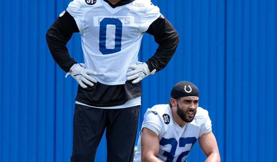 Indianapolis Colts safety Camryn Bynum (0) and safety Daniel Scott (32) watch drills during the NFL football team's practice in Indianapolis, Tuesday, June 9, 2026. (AP Photo/Michael Conroy)
