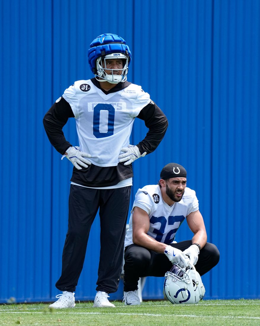 Indianapolis Colts safety Camryn Bynum (0) and safety Daniel Scott (32) watch drills during the NFL football team's practice in Indianapolis, Tuesday, June 9, 2026. (AP Photo/Michael Conroy)
