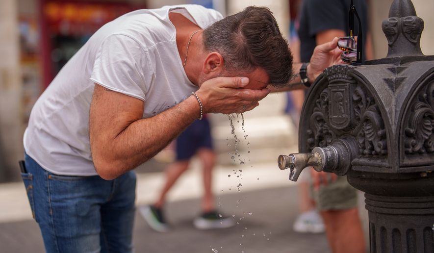 A man cools off in a fountain during a hot and sunny day of summer in Madrid, Spain, July 19, 2023. (AP Photo/Manu Fernandez, File)