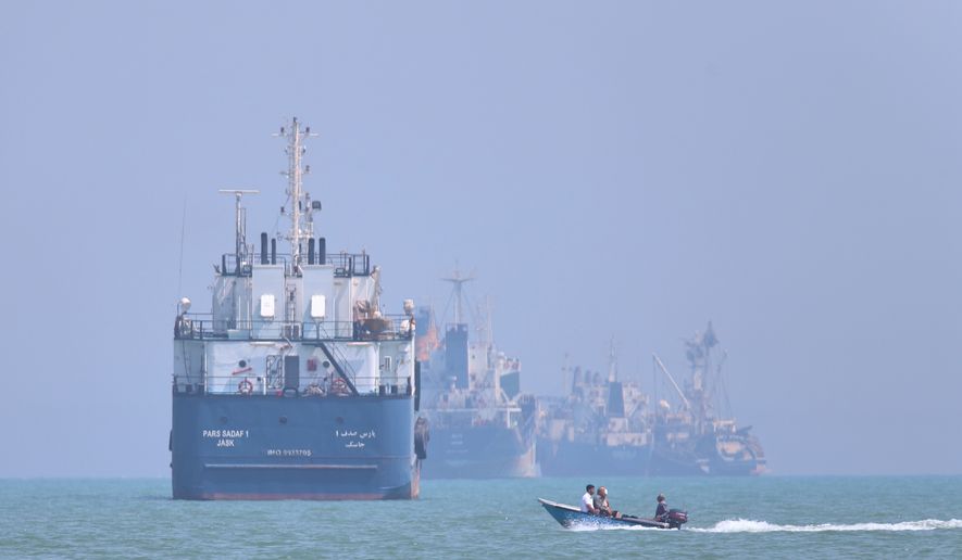 A small motorboat passes anchored vessels in the Strait of Hormuz off Bandar Abbas, Iran, Thursday, June 11, 2026.(Amirhosein Khorgooi/ISNA via AP)