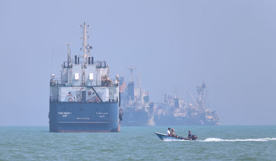 A small motorboat passes anchored vessels in the Strait of Hormuz off Bandar Abbas, Iran, Thursday, June 11, 2026.(Amirhosein Khorgooi/ISNA via AP)
