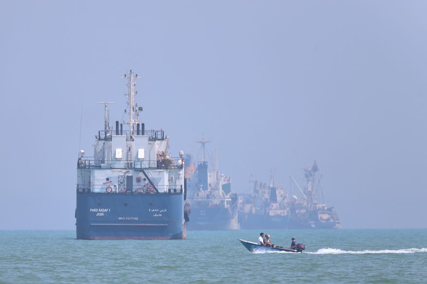 A small motorboat passes anchored vessels in the Strait of Hormuz off Bandar Abbas, Iran, Thursday, June 11, 2026.(Amirhosein Khorgooi/ISNA via AP)