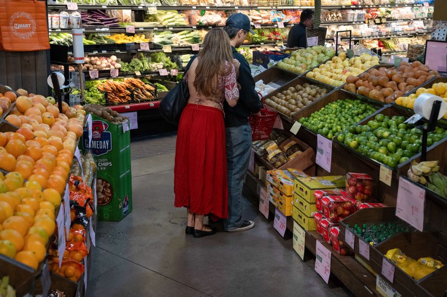 People shop in the produce section of a grocery store on Monday, May 11, 2026, in Portland, Ore. (AP Photo/Jenny Kane)