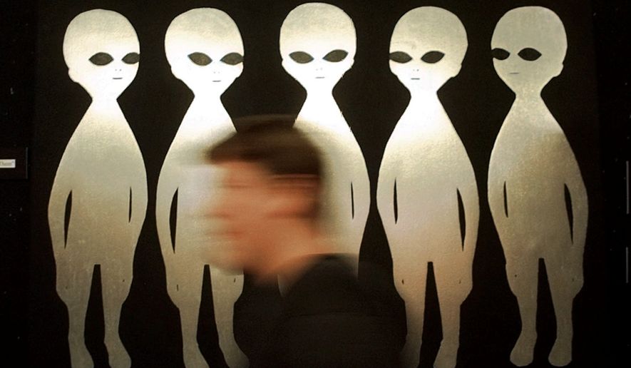 A patron passes a painting inside the International UFO Museum and Research Center in Roswell, N.M., on June 10, 1997. (AP Photo/Eric Draper) **FILE**