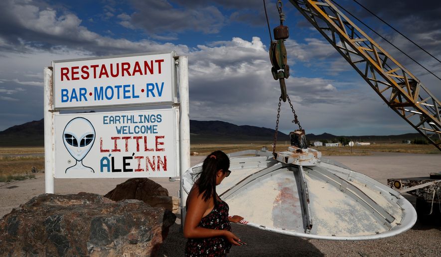 A woman looks at a UFO display outside of the Little A'Le'Inn, in Rachel, Nev., the closest town to Area 51, July 22, 2019. (AP Photo/John Locher, File)