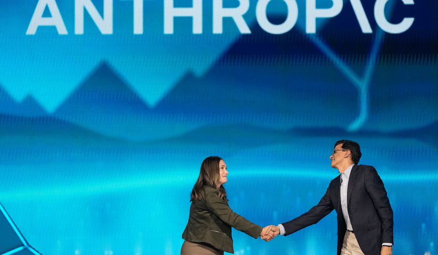 Anthropic co-founder and President Daniela Amodei, left, shakes hands with Snowflake CEO Sridhar Ramaswamy during the keynote presentaton at Snowflake Summit 26 Monday, June 1, 2026, in San Francisco. (AP Photo/Jeff Chiu)