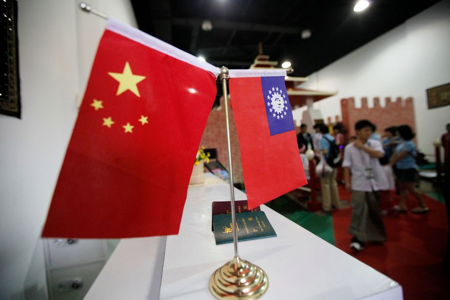 Flags of China and Myanmar are displayed at the entrance of Myanmar Pavilion prior to Myanmar's top junta leader Gen. Than Shwe to arrive at the Shanghai Expo site in Shanghai Friday, Sept.10, 2010. (AP Photo/Eugene Hoshiko, file)