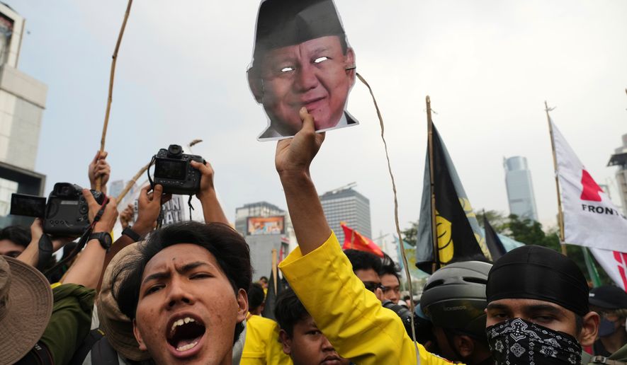 A student protester holds up a mask of Indonesian President Prabowo Subianto during a rally against a fuel price hike, government inefficient spendings, and military involvement in civilian affairs in Jakarta, Indonesia, Friday, June 12, 2026. (AP Photo/Tatan Syuflana)