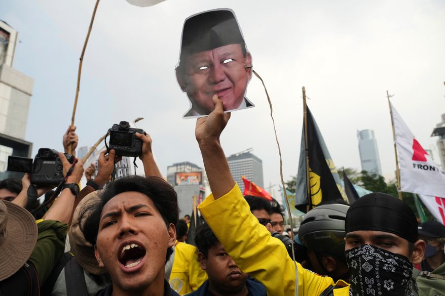 A student protester holds up a mask of Indonesian President Prabowo Subianto during a rally against a fuel price hike, government inefficient spendings, and military involvement in civilian affairs in Jakarta, Indonesia, Friday, June 12, 2026. (AP Photo/Tatan Syuflana)