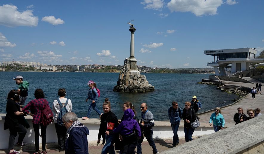 FILE - Tourists walk along an embankment in Sevastopol, Crimea, Monday, May 2, 2022. (AP Photo, File)