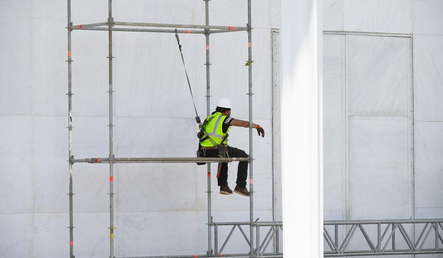 A worker sits on scaffolding at the John F. Kennedy Center for the Performing Arts in Washington, Friday, June 12, 2026. (AP Photo/Cliff Owen)