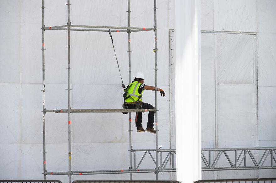 A worker sits on scaffolding at the John F. Kennedy Center for the Performing Arts in Washington, Friday, June 12, 2026. (AP Photo/Cliff Owen)