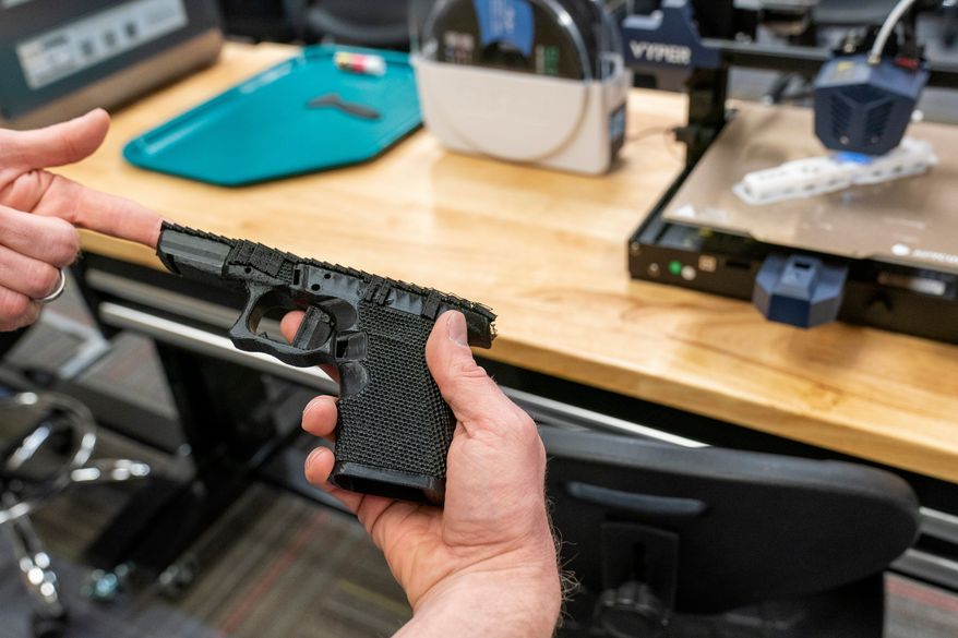 A handgun frame that has been printed on a 3D printer is held for a photograph at the Bureau of Alcohol, Tobacco, Firearms, and Explosives (ATF), National Services Center, March 2, 2023, in Martinsburg, W.Va. (AP Photo/Alex Brandon, File)