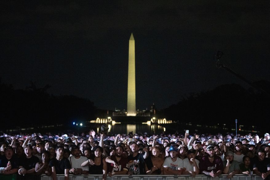 Audience members cheer and boo during a UFC news conference at the Lincoln Memorial, ahead of Sunday's fight on the South Lawn of the White House, Friday, June 12, 2026, in Washington. (AP Photo/Allison Robbert)