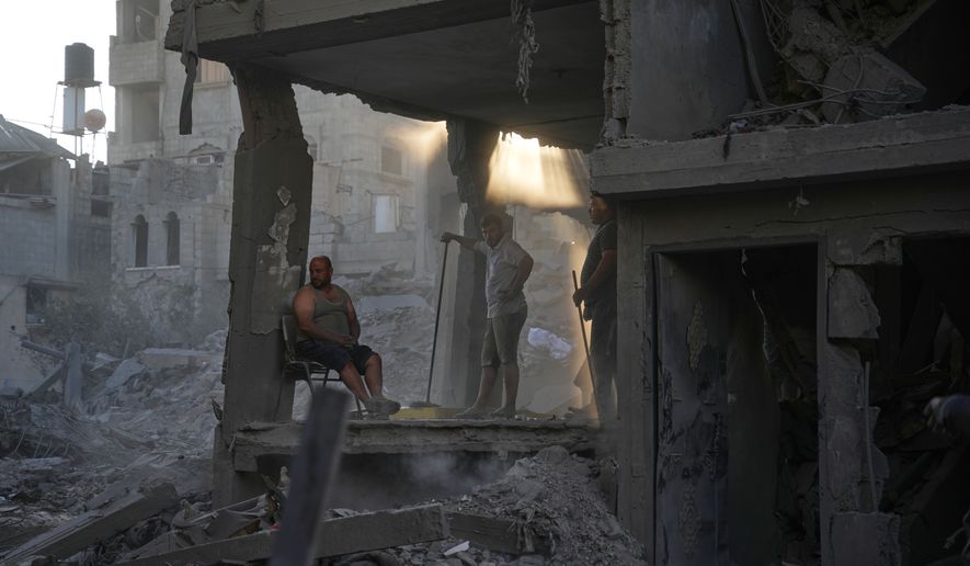 Palestinians clear the rubble of a building that was destroyed in an Israeli airstrike, at al-Maghazi refugee camp, central Gaza Strip, Friday, June 12, 2026. (AP Photo/Abdel Kareem Hana)