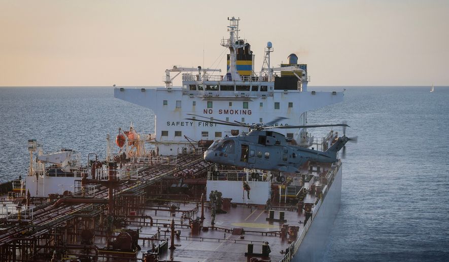 In this photo provided by the Royal Navy, Royal Marine Commandos detain sanctioned tanker, the Smyrtos, in the English Channel, Sunday, June 14, 2026. (LPhot Hutchins/Royal Navy via AP)