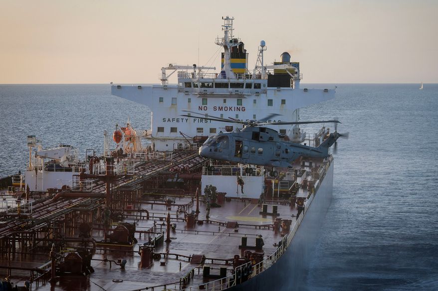 In this photo provided by the Royal Navy, Royal Marine Commandos detain sanctioned tanker, the Smyrtos, in the English Channel, Sunday, June 14, 2026. (LPhot Hutchins/Royal Navy via AP)