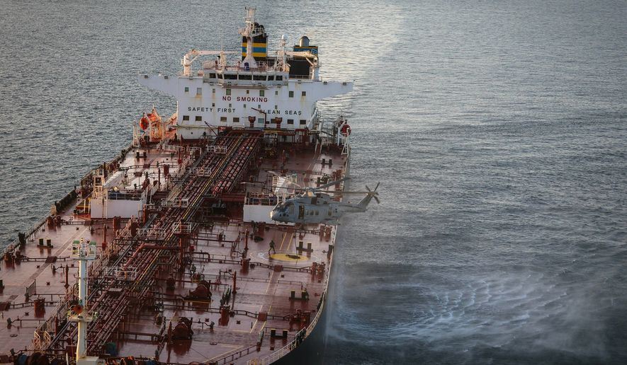 In this photo provided by the Royal Navy, Royal Marine Commandos detain sanctioned tanker, the Smyrtos, in the English Channel, Sunday, June 14, 2026. (LPhot Hutchins/Royal Navy via AP)