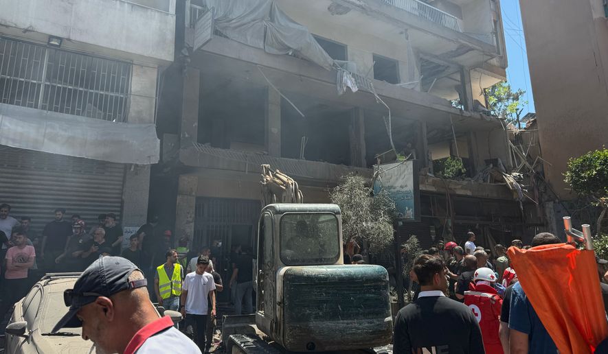 People gather at the site of an Israeli airstrike that struck an apartment in Dahiyeh, Beirut's southern suburbs, Lebanon, Sunday, June 14, 2026. (AP Photo/Bilal Hussein)