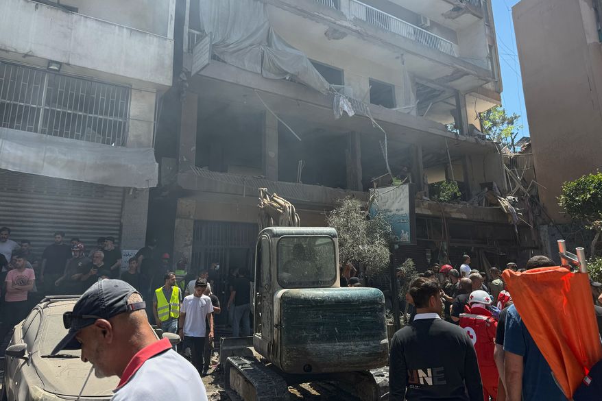 People gather at the site of an Israeli airstrike that struck an apartment in Dahiyeh, Beirut's southern suburbs, Lebanon, Sunday, June 14, 2026. (AP Photo/Bilal Hussein)