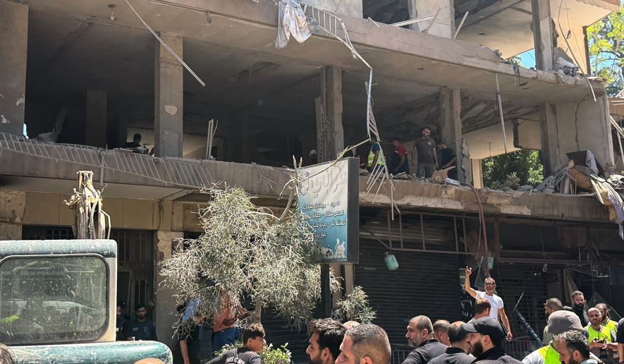 People gather at the site of an Israeli airstrike that struck an apartment in Dahiyeh, Beirut's southern suburbs, Lebanon, Sunday, June 14, 2026. (AP Photo/Bilal Hussein)
