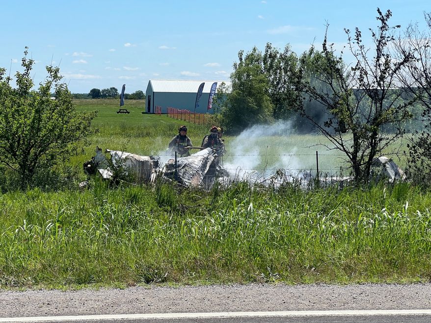 The wreckage of a plane crash burns in a field in Butler, Mo, Sunday, June 14, 2026. (Mid America News Review via AP Photo )